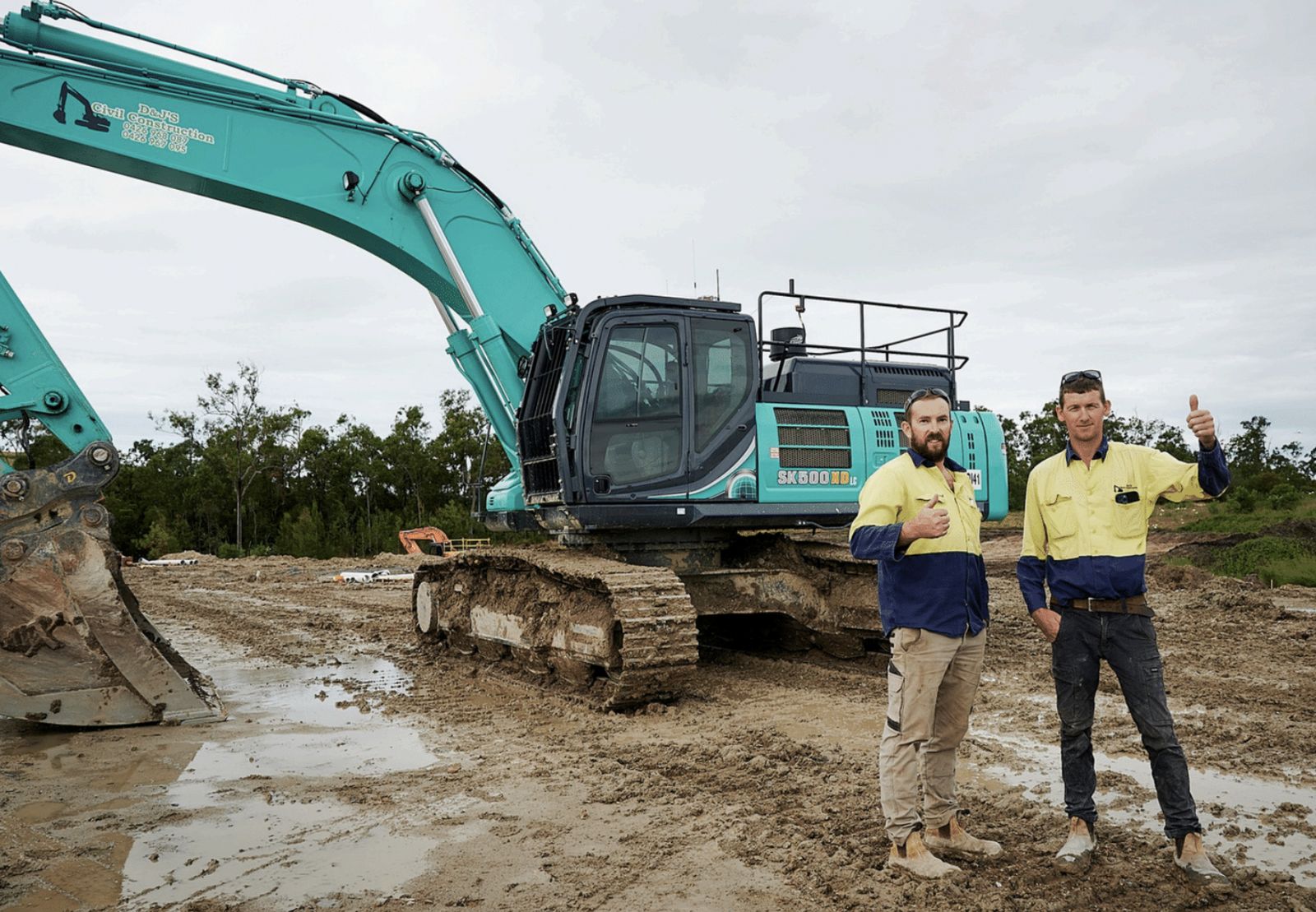 Directors Darren O'Mahony and James Horgan on site in front of a D&J's Kobelco excavator